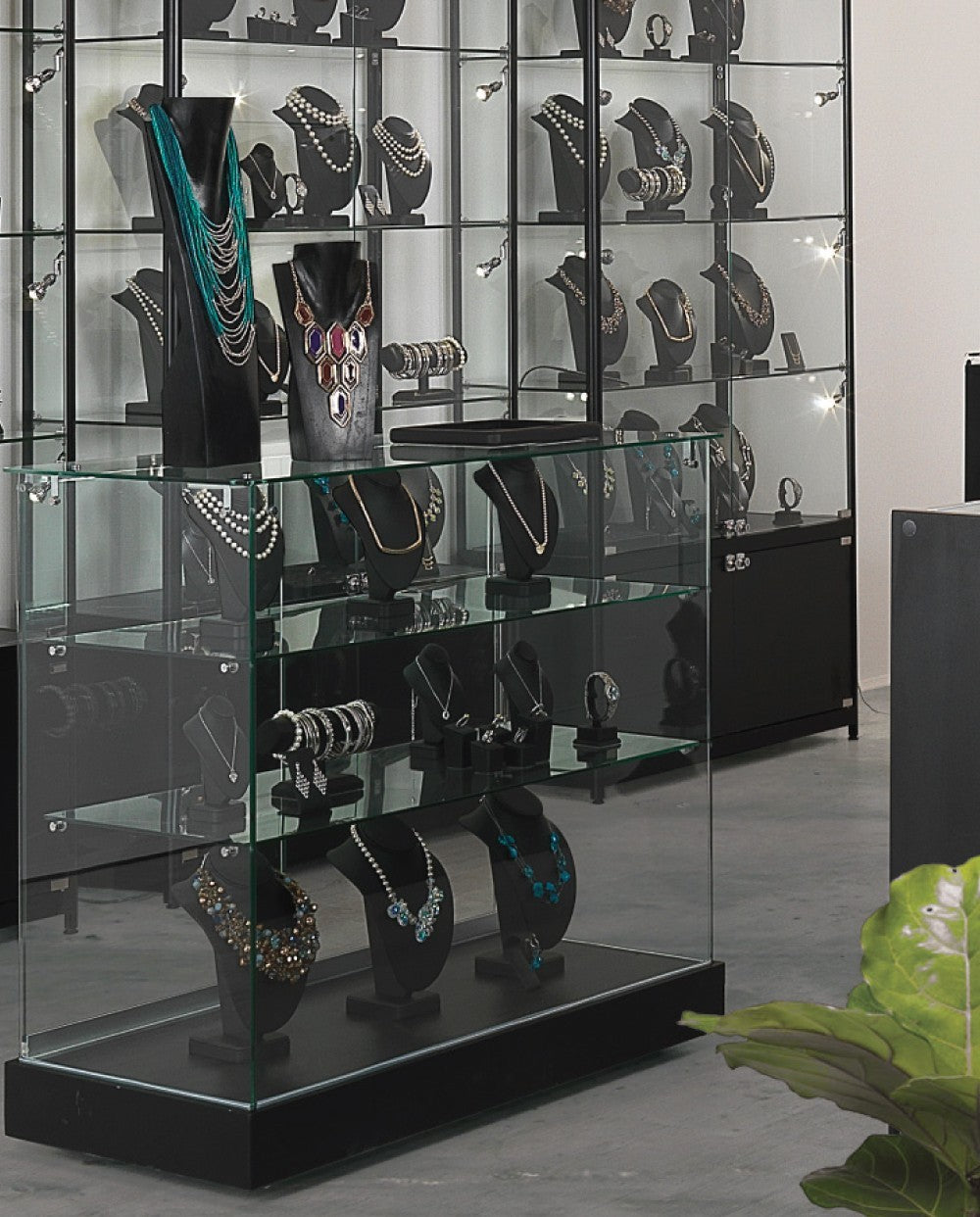 SuperSellerS Toscana III black glass display counter with two shelves, sliding doors, and jewelry mannequins.